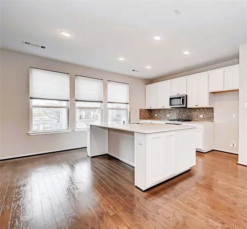 a view of a livingroom with a kitchen counter top space cabinets and appliances