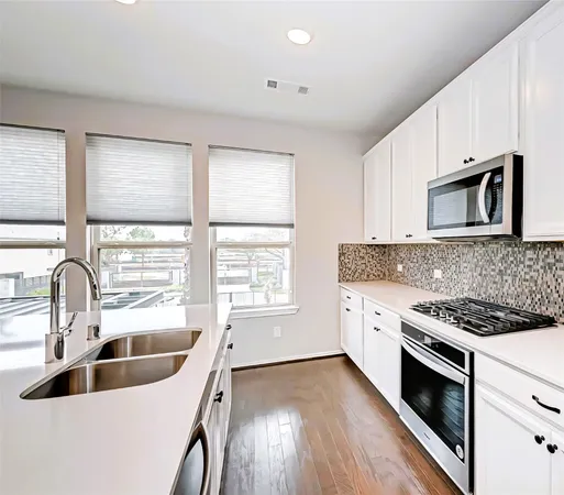 a kitchen with granite countertop white cabinets and white appliances