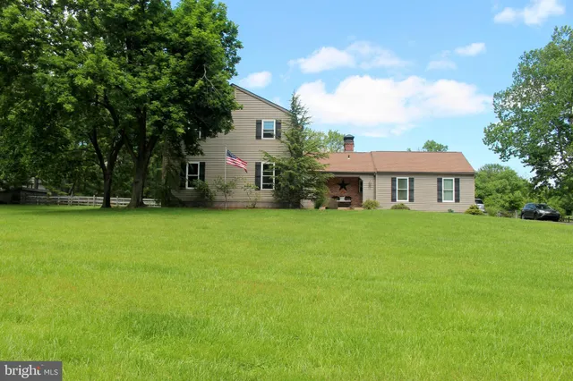 a view of a house with a yard and sitting area