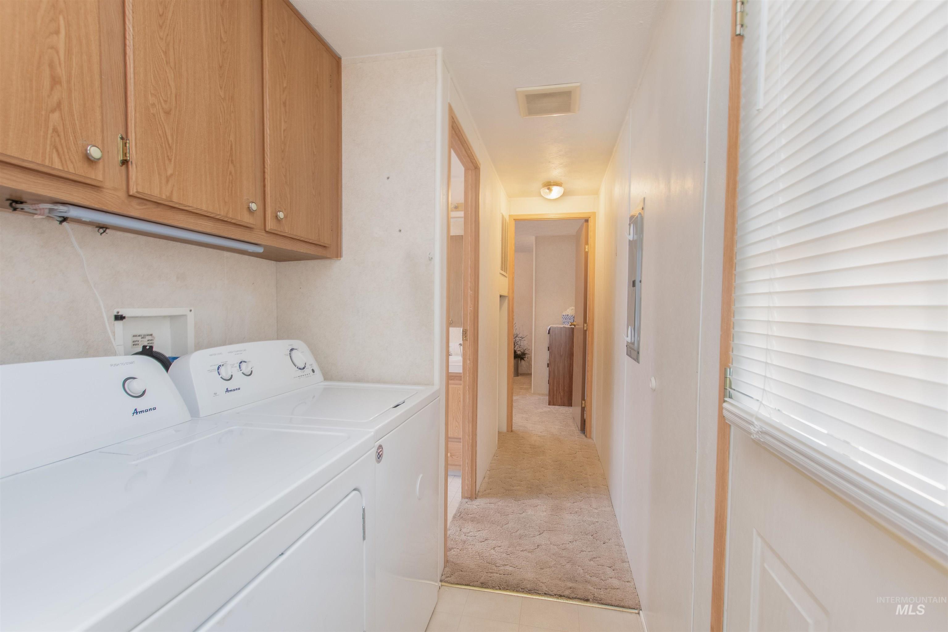 815 South Curtis Road, Unit 19 Boise, ID 83705 - Photo 11 of 25 Laundry room featuring light colored carpet, washing machine and dryer, and cabinet space
