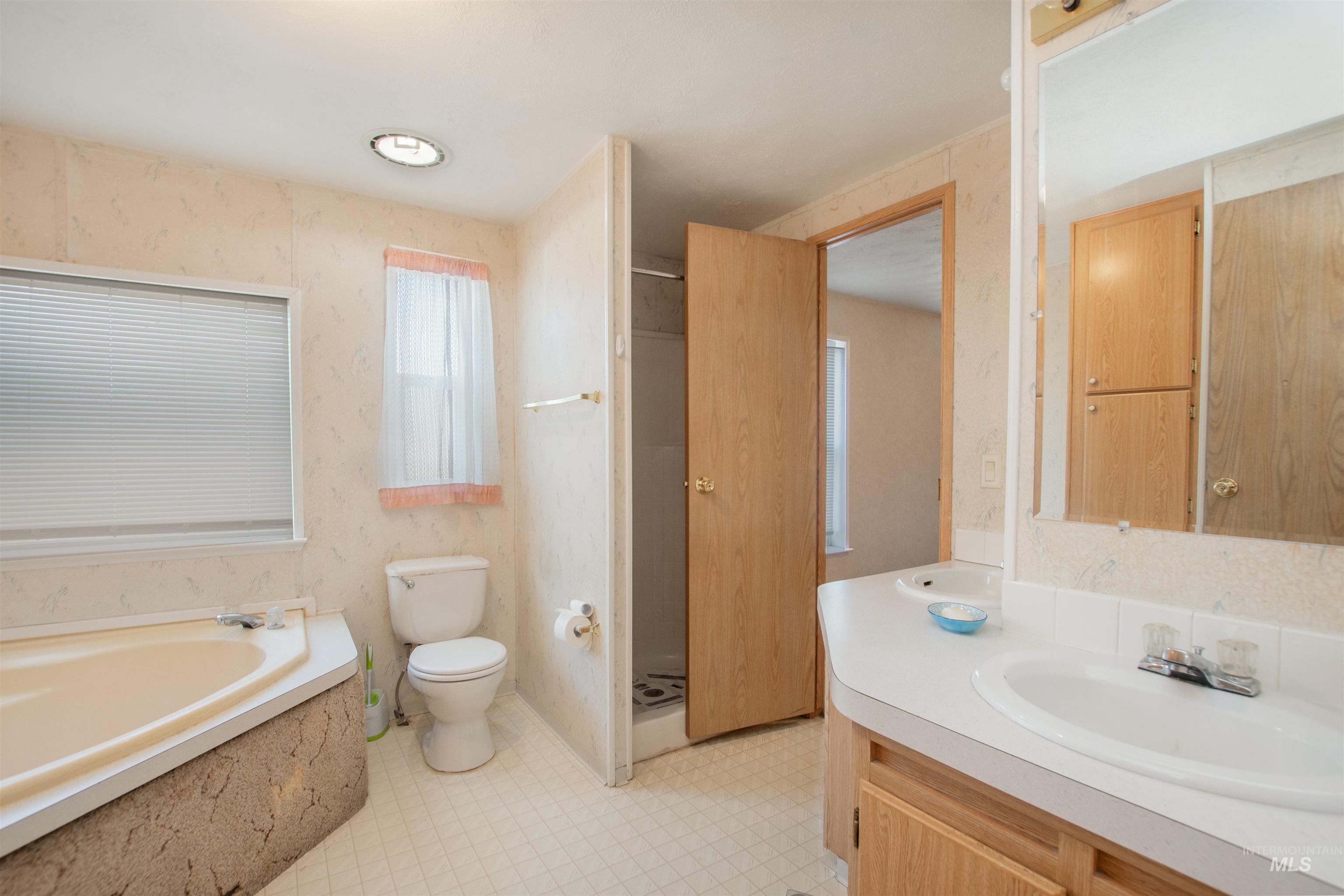 815 South Curtis Road, Unit 19 Boise, ID 83705 - Photo 17 of 25 Full bathroom featuring wallpapered walls, vanity, a bath, and light floors