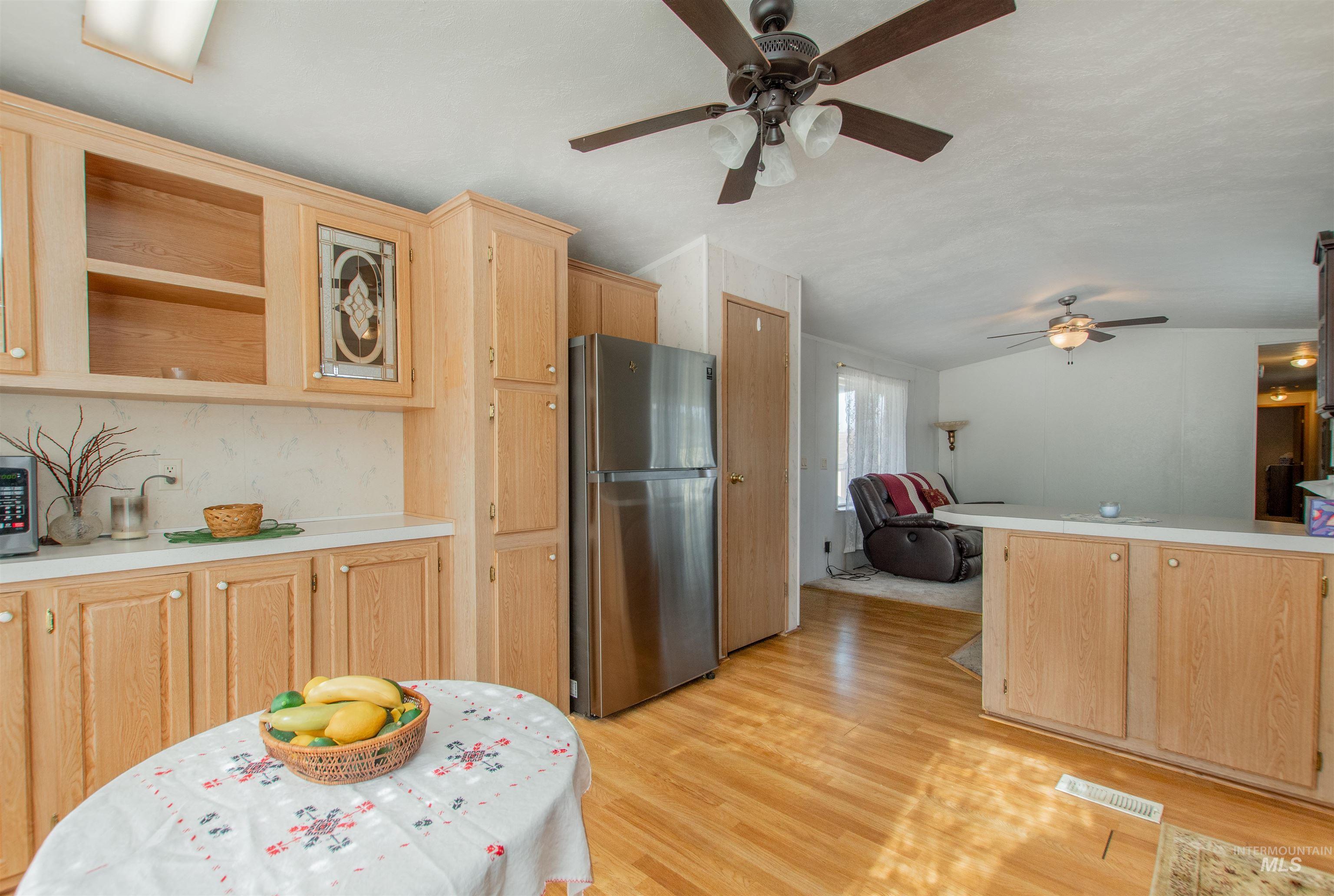 815 South Curtis Road, Unit 19 Boise, ID 83705 - Photo 4 of 25 Kitchen featuring light wood finish cabinets, light countertops, stainless steel appliances, a ceiling fan, and light wood-style flooring