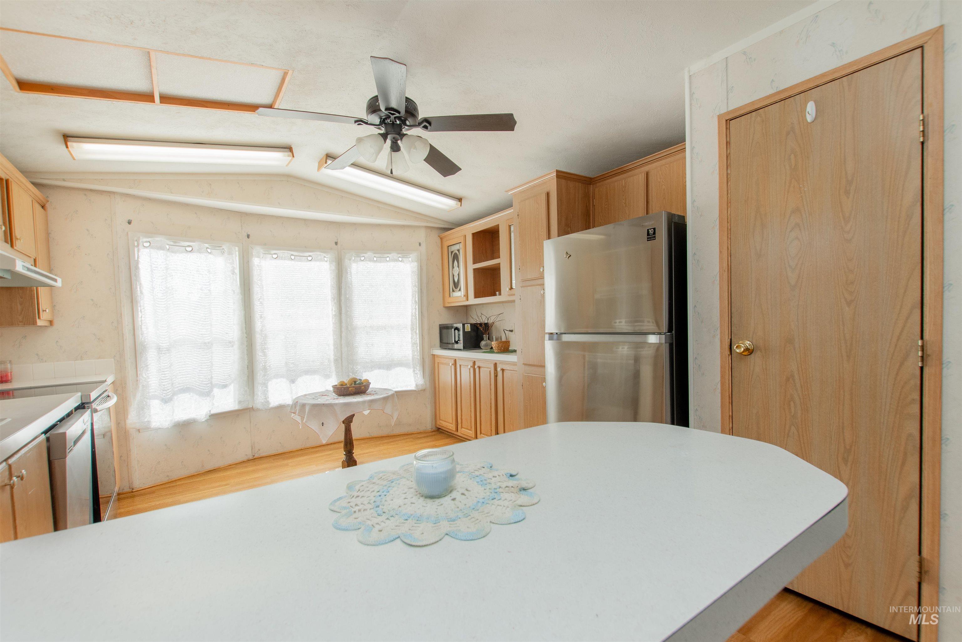 815 South Curtis Road, Unit 19 Boise, ID 83705 - Photo 5 of 25 Kitchen with stainless steel appliances, lofted ceiling, light wood finish cabinets, light countertops, and light wood-style flooring