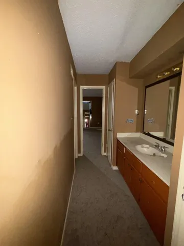 a view of a hallway with kitchen and sink