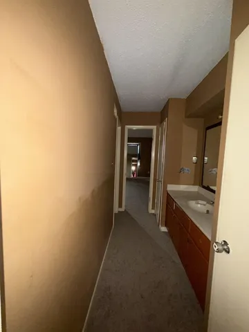 a view of a hallway to a house and bathroom