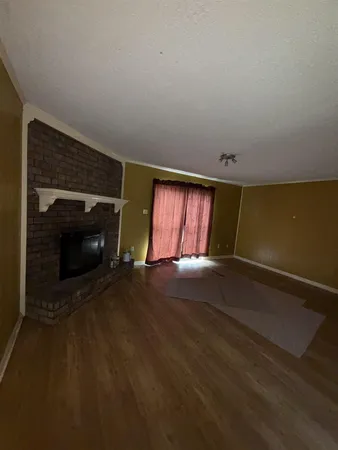 a view of empty room with window and fireplace