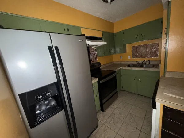 a kitchen with sink refrigerator and stove