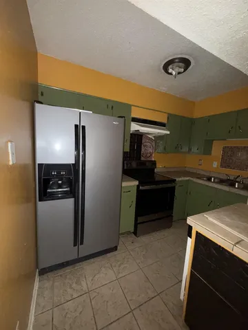 a kitchen with a refrigerator and a sink