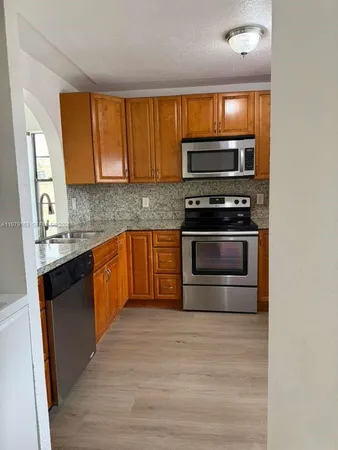 a kitchen with stainless steel appliances granite countertop a stove a sink and a microwave