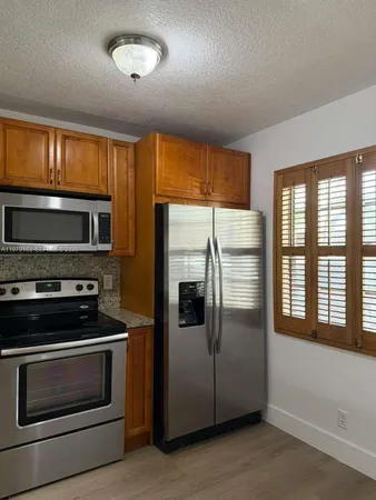 a metallic refrigerator freezer sitting in a kitchen