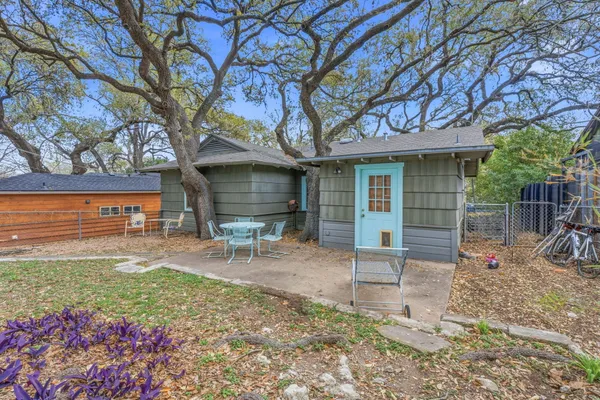 a view of a chair and table in backyard of the house