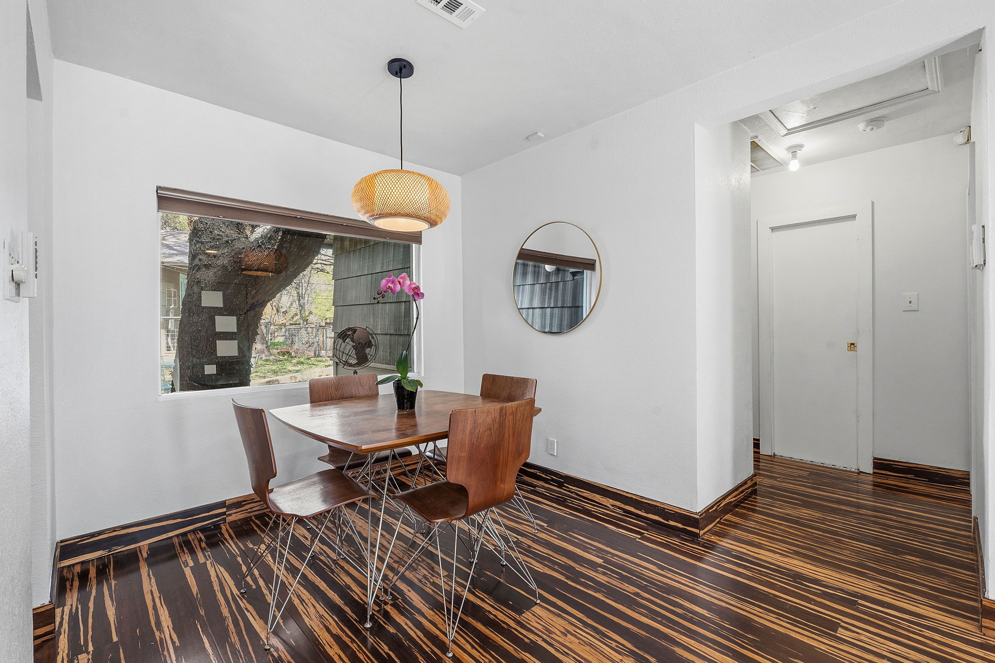 1112 Mission Ridge Austin, TX 78704 - Photo 3 of 22 a dining room with wooden floor a glass table and chairs