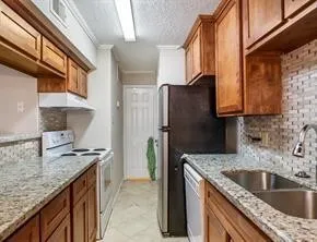 a kitchen with granite countertop a sink stove and refrigerator