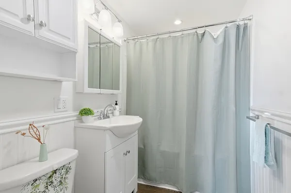 a bathroom with a sink a mirror and a shower curtain