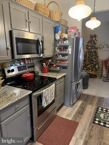 a kitchen with stainless steel appliances a stove refrigerator and microwave