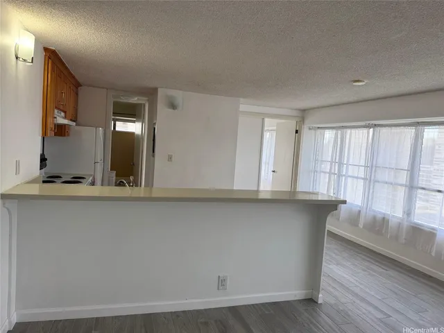 a view of kitchen with granite countertop cabinets and wooden floor