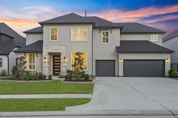 a front view of a house with a yard and garage