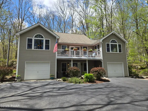 a front view of a house with a garden and garage