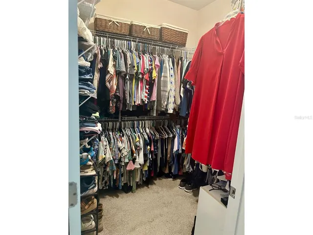 a view of walk in closet with clothes
