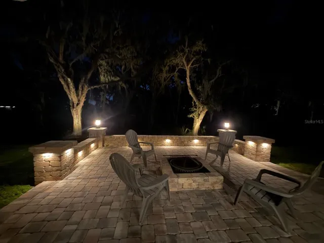 a roof deck with table and chairs and potted plants