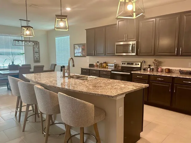 a kitchen with stainless steel appliances granite countertop a sink a stove and microwave