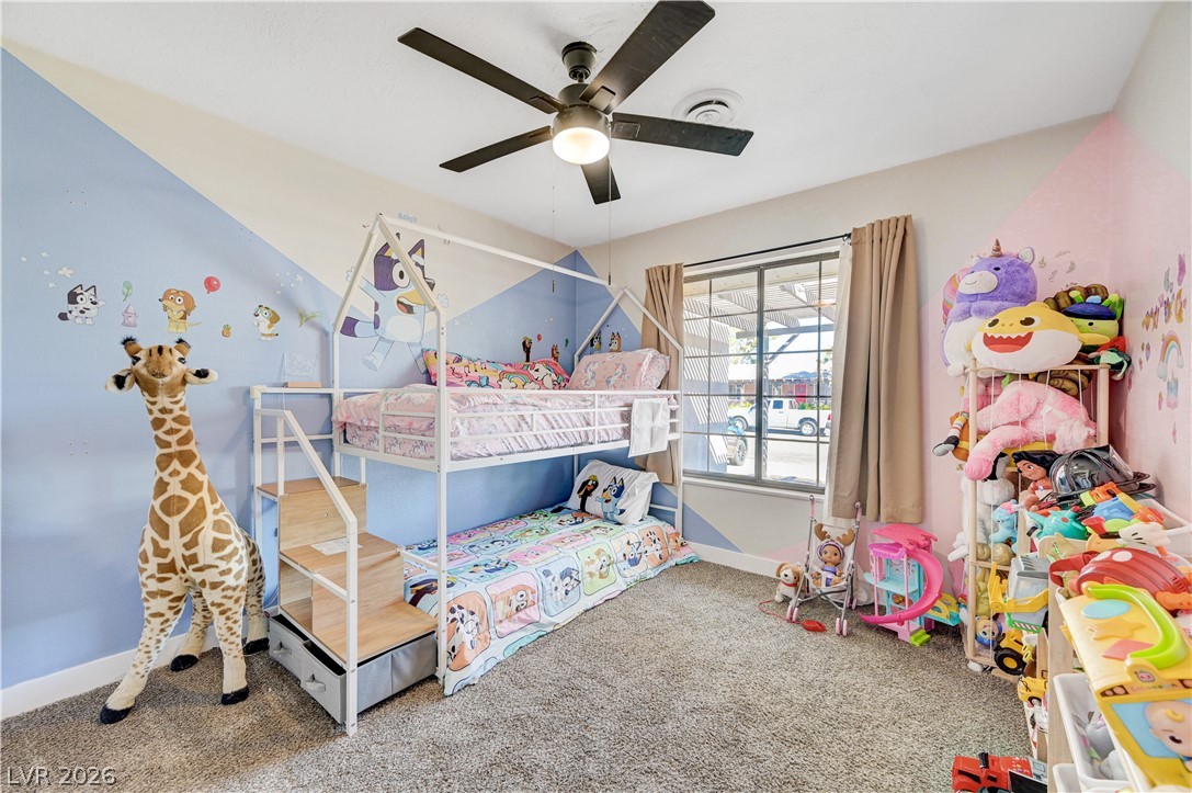 1331 Pinto Road Boulder City, NV 89005 - Photo 6 of 46 A cheerful children's bedroom features plush carpeting, a modern bunk bed, and a functional ceiling fan.