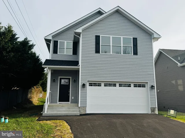 a view of a house with a yard and large tree