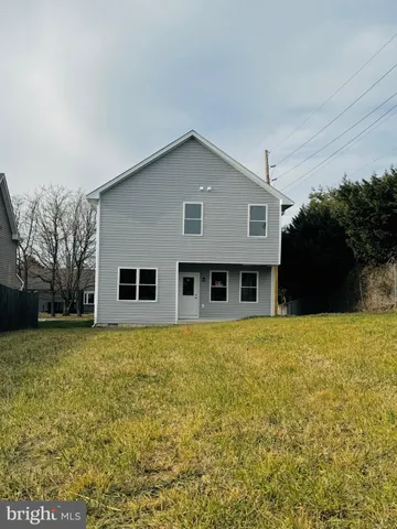 a front view of house with yard and trees in the background