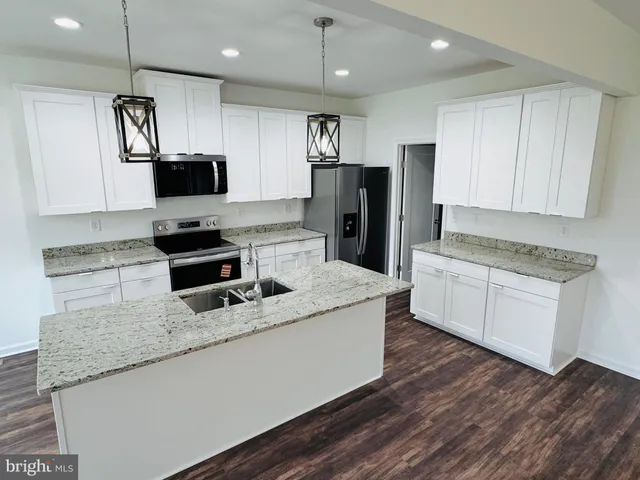 a kitchen with stainless steel appliances granite countertop a sink dishwasher a refrigerator a microwave oven with granite countertops and cabinets