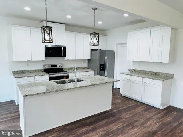 a kitchen with stainless steel appliances granite countertop a sink refrigerator and microwave