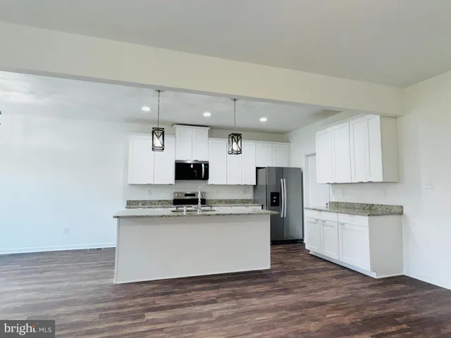 a kitchen with stainless steel appliances a sink a stove a refrigerator and cabinets