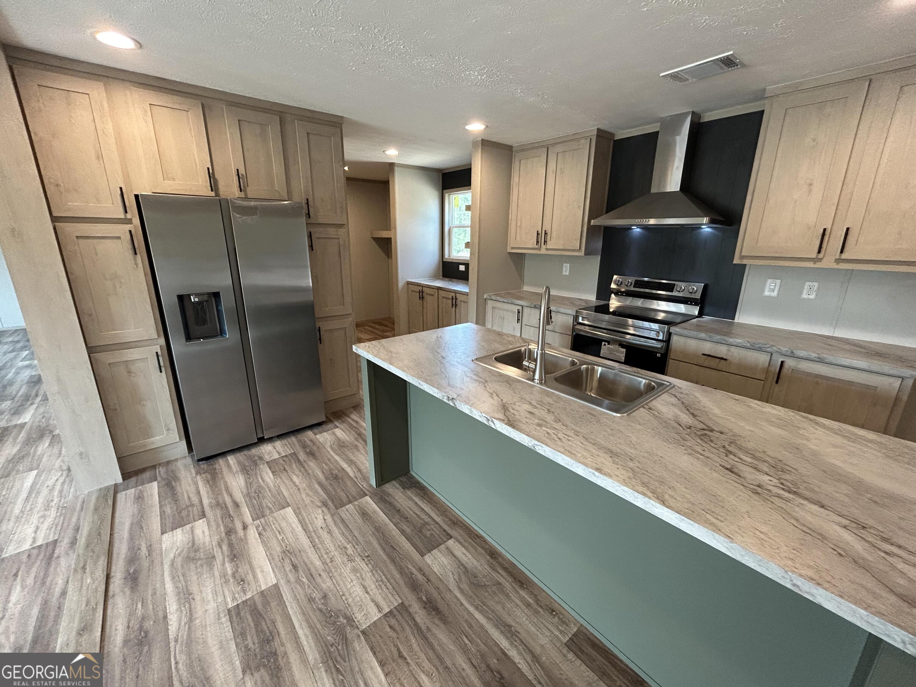 640 Elmer Thrift Road Waycross, GA 31503 - Photo 9 of 23 a kitchen with stainless steel appliances wooden cabinets a refrigerator and a sink