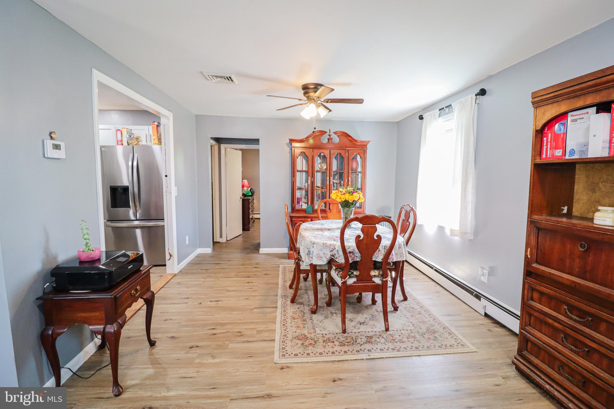 156 South Ritters Lane Owings Mills, MD 21117 - Photo 7 of 42 a dining room with wooden floor a chandelier a wooden table and chairs
