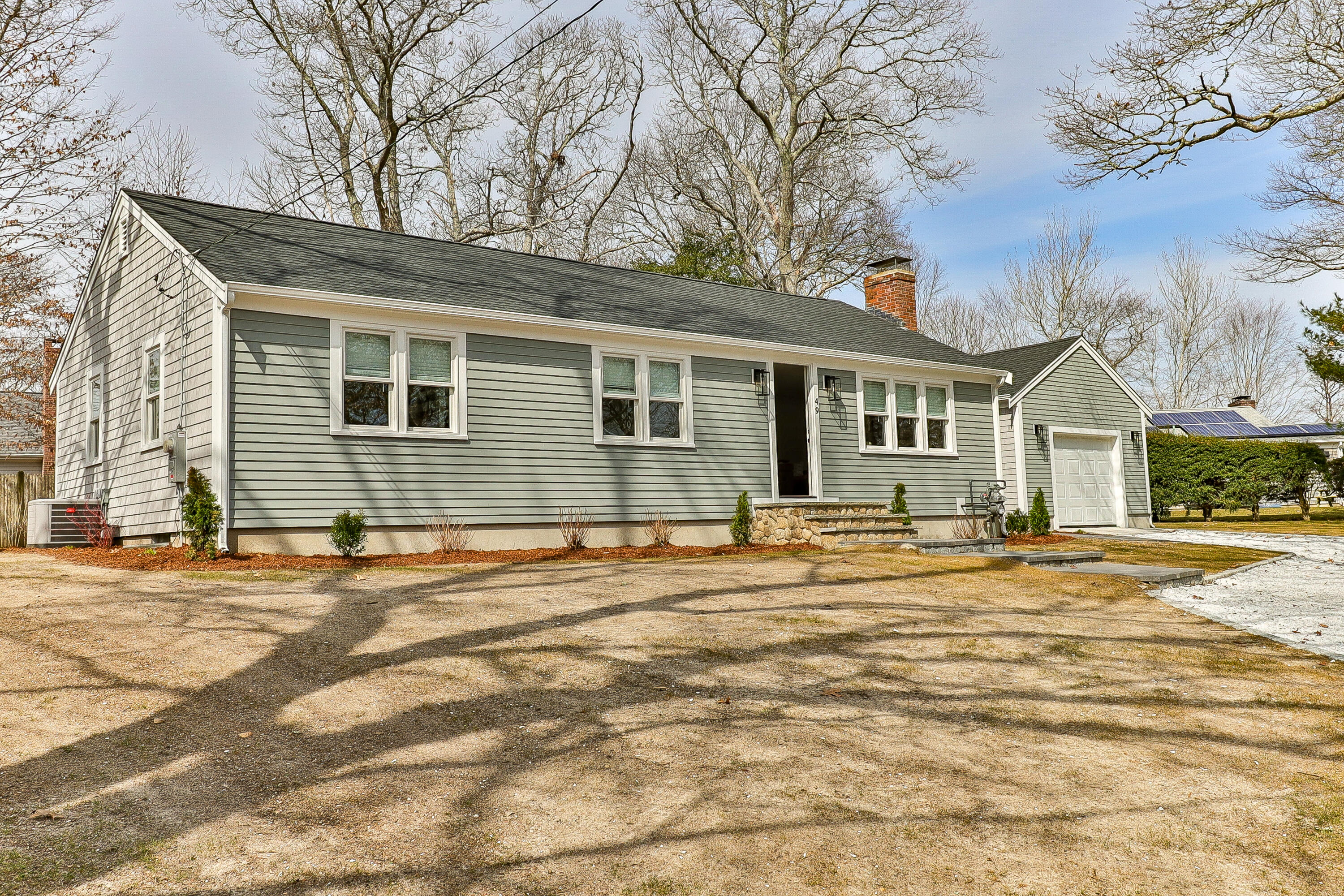 49 Huckins Neck Road Centerville, MA 02632 - Photo 1 of 23 a front view of a house with a garden