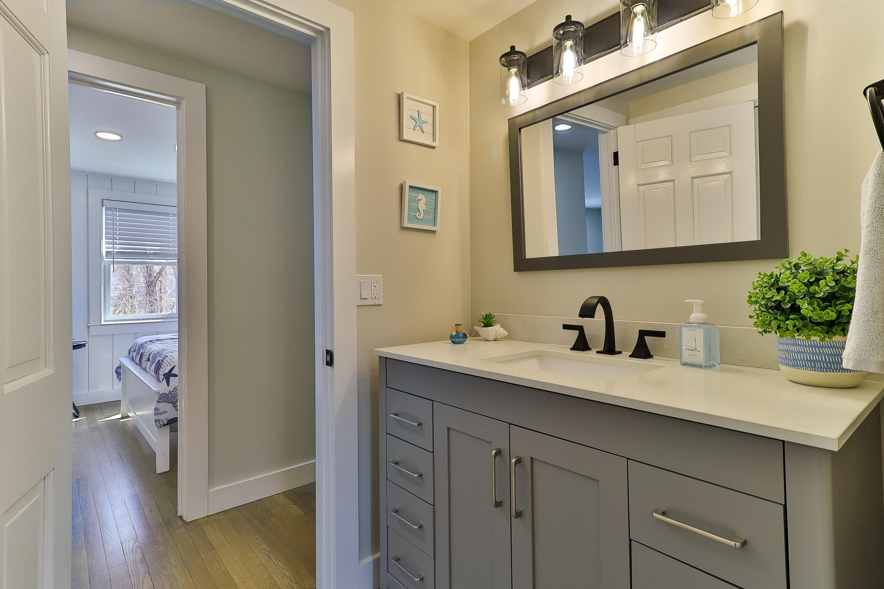 49 Huckins Neck Road Centerville, MA 02632 - Photo 14 of 23 a en suite bathroom with a granite countertop sink and a mirror