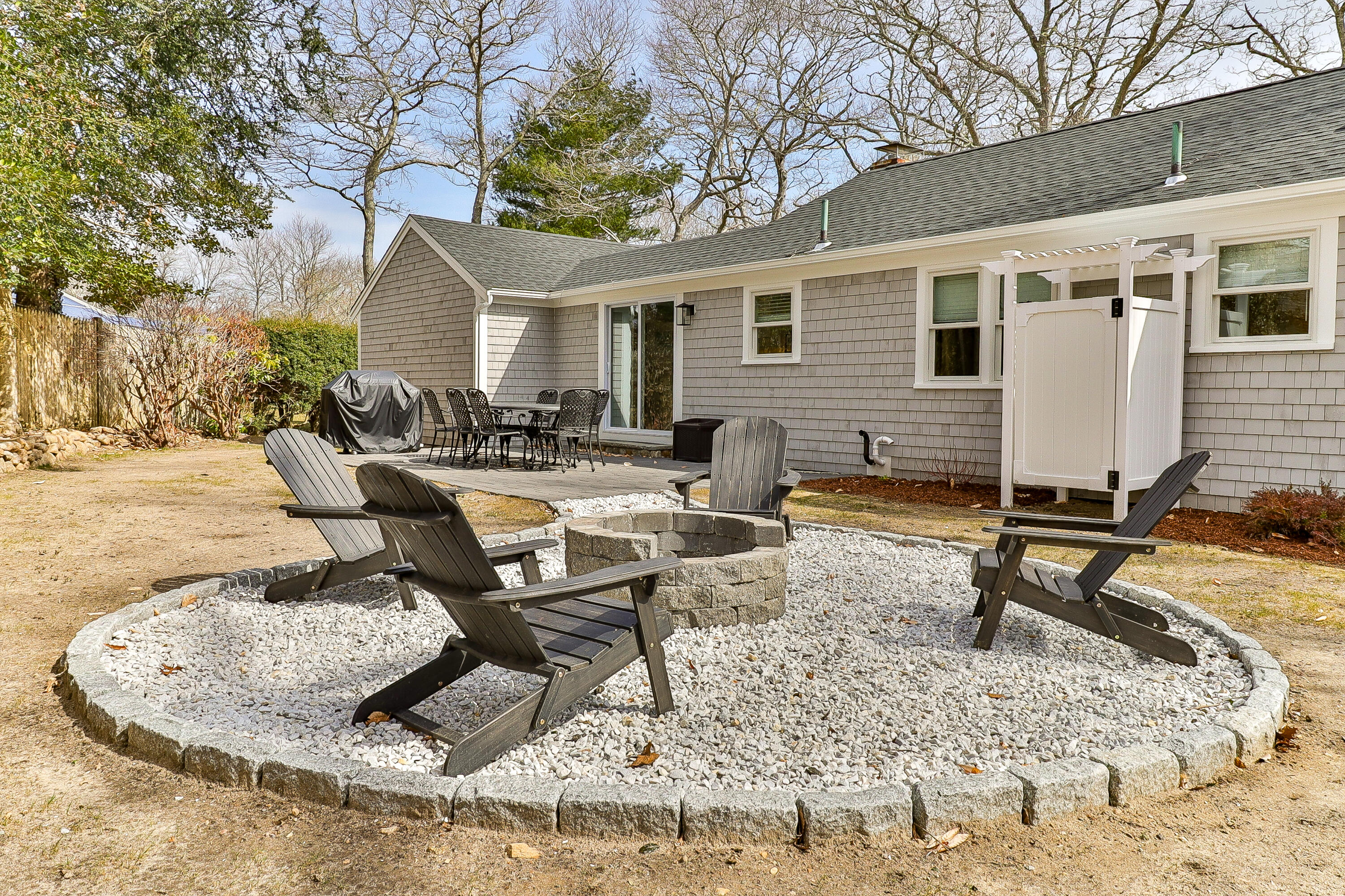 49 Huckins Neck Road Centerville, MA 02632 - Photo 22 of 23 a view of a backyard with table and chairs
