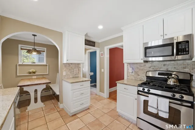 a kitchen with stainless steel appliances kitchen island granite countertop a stove and a microwave