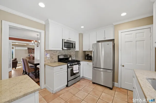 a kitchen with a refrigerator a stove top oven and cabinets