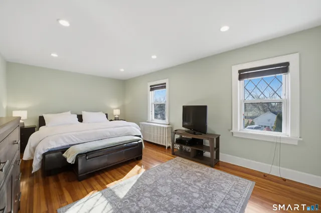 a bedroom with a bed and wooden floor