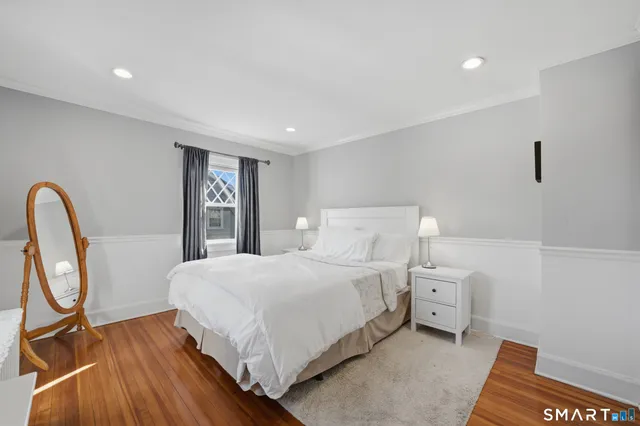 a bedroom with a bed a mirror and a table in it