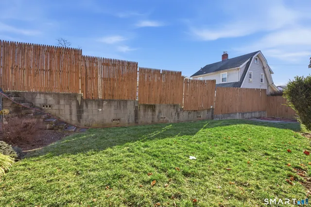 a view of a backyard with wooden fence