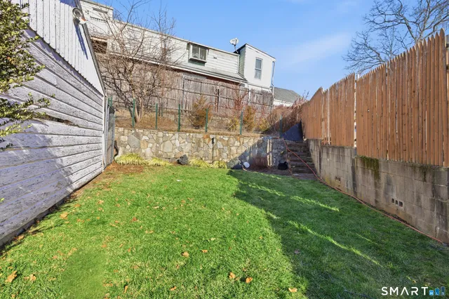 a view of a back yard with a wooden fence