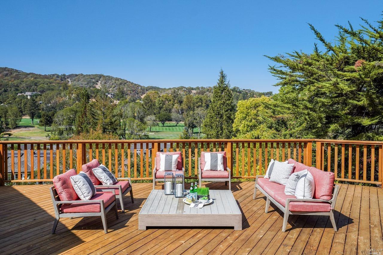 a view of a balcony with wooden floor and outdoor seating
