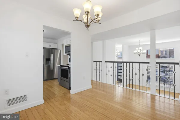 a view of a hallway with wooden floor and a living room