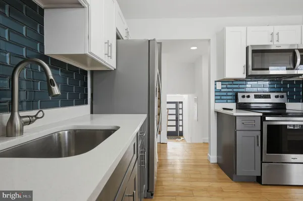 a kitchen with kitchen island a counter top a stove and a sink