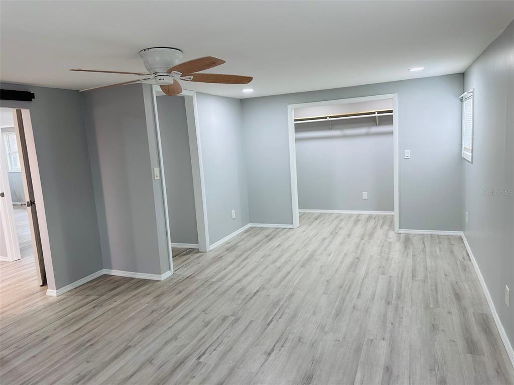 13750 Northwest 88th Terrace Chiefland, FL 32626 - Photo 12 of 33 a room with wooden floor and a ceiling fan