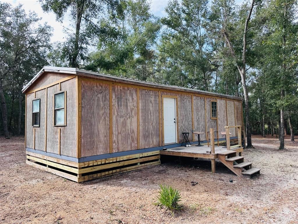 13750 Northwest 88th Terrace Chiefland, FL 32626 - Photo 33 of 33 a backyard of a house with a bench and wooden fence