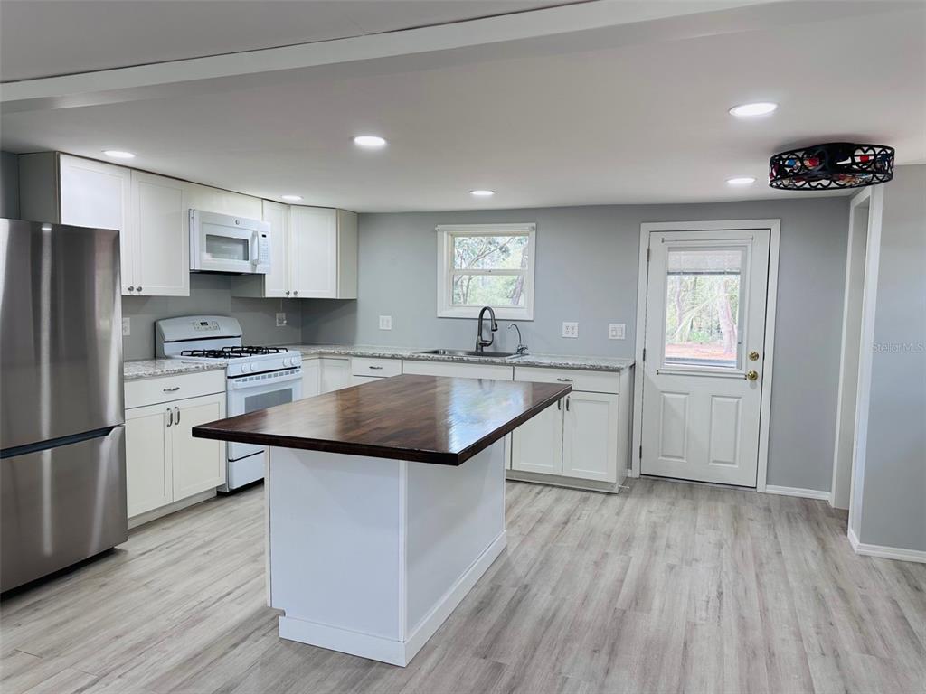 13750 Northwest 88th Terrace Chiefland, FL 32626 - Photo 7 of 33 a kitchen with granite countertop a sink cabinets and stainless steel appliances