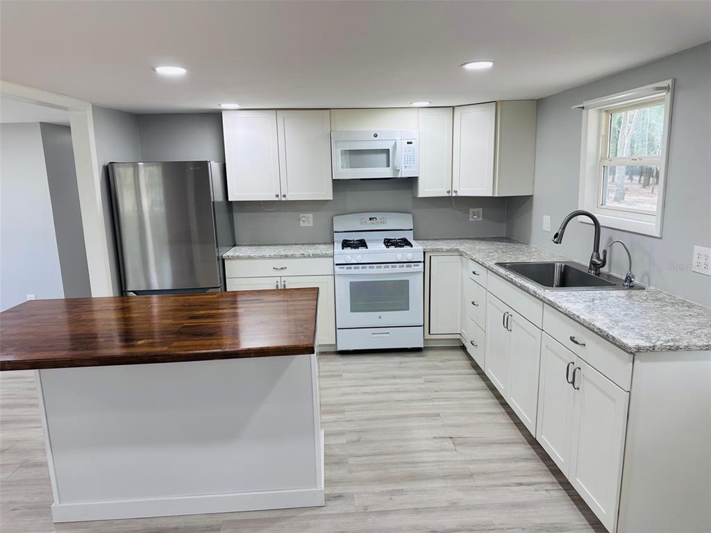 13750 Northwest 88th Terrace Chiefland, FL 32626 - Photo 10 of 33 a kitchen with stainless steel appliances granite countertop a sink a stove and a refrigerator
