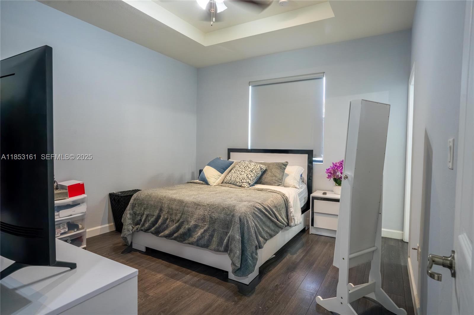 11571 Southwest 248th Lane Homestead, FL 33032 - Photo 19 of 26 a bed sitting in a bedroom next to a window with tv